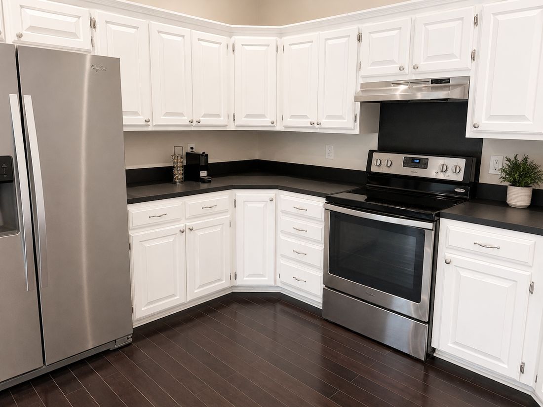 Furnished kitchen with stainless steel appliances and white cabinets at Casa Rita, Bentonville AR